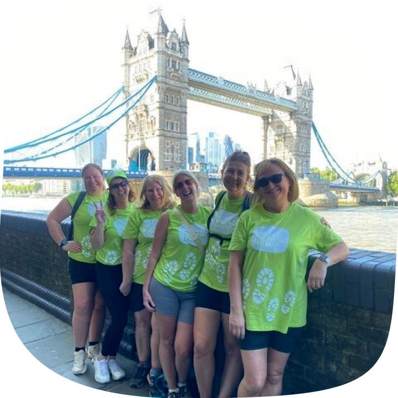 A group of six people taking part in the Banham Marsden march at Home. They're standing in front of Tower Bridge in London