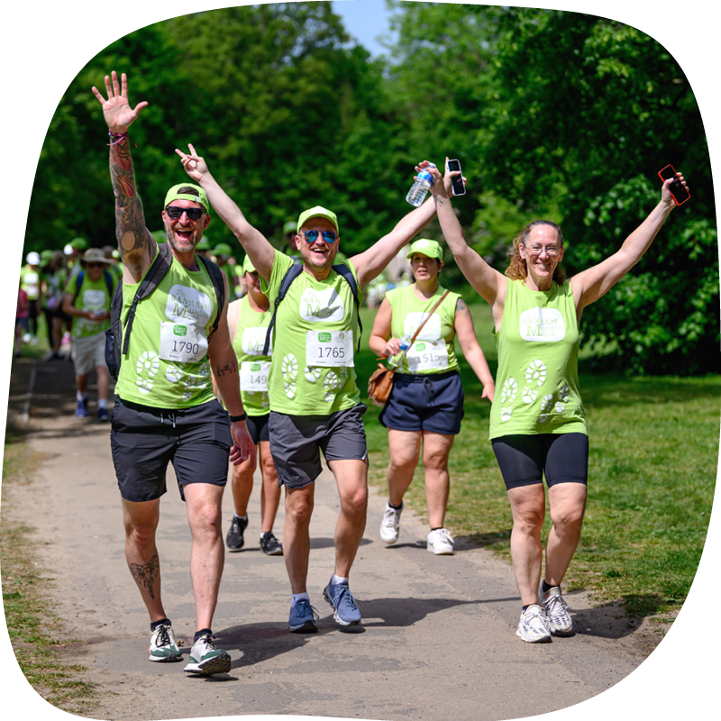 A group of Banham Marsden Marchers walking through a park, they are smiling with their hands up in the air A group of Banham Marsden Marchers walking through a park, they are smiling with their hands up in the air
